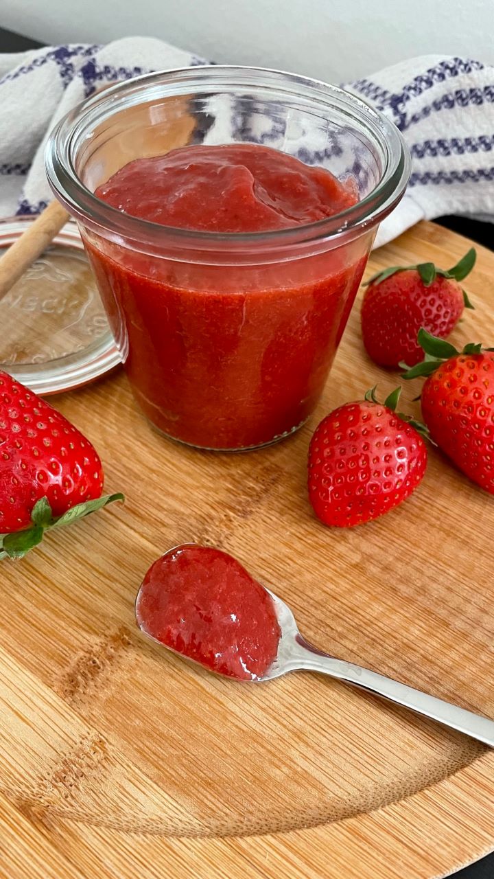 Rhabarbeer-Erdbeer-Marmelade im Glas und auf einem Löffel